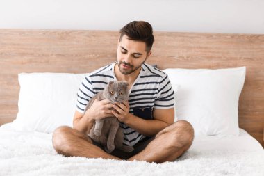 Evde sevimli komik kedi ile genç adam