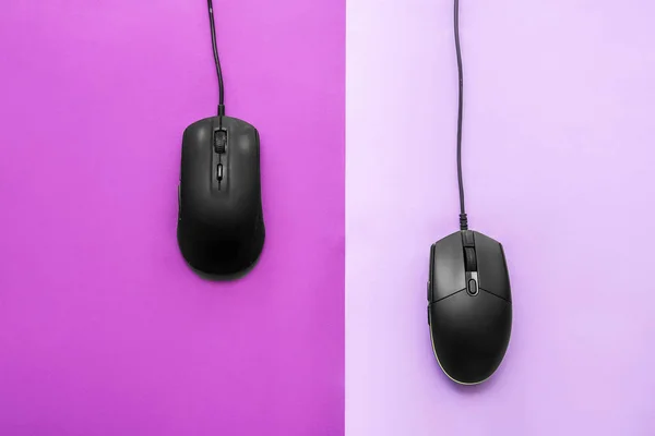 Modern gaming mouse devices on color background