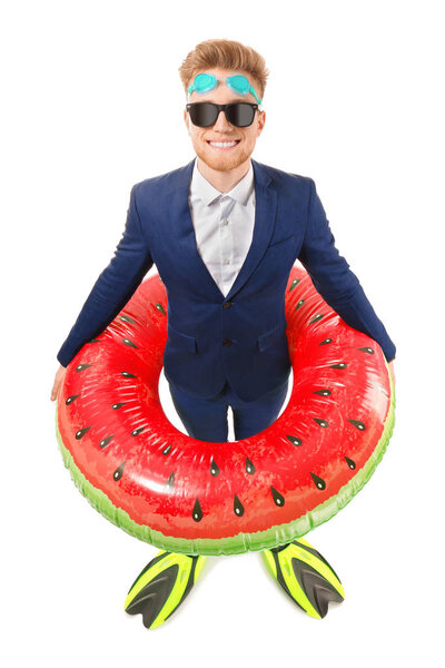 Забавный молодой турист в костюме и с надувным кольцом и ластами на белом фоне
