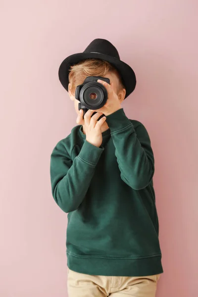 Симпатичный маленький фотограф с профессиональной камерой на цветном фоне — стоковое фото