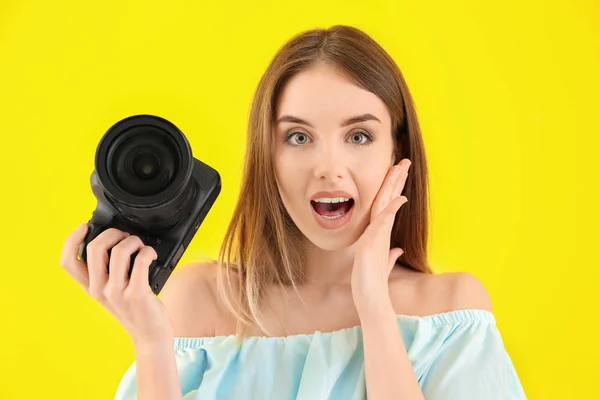 Verwarde vrouwelijke fotograaf op kleur achtergrond — Stockfoto