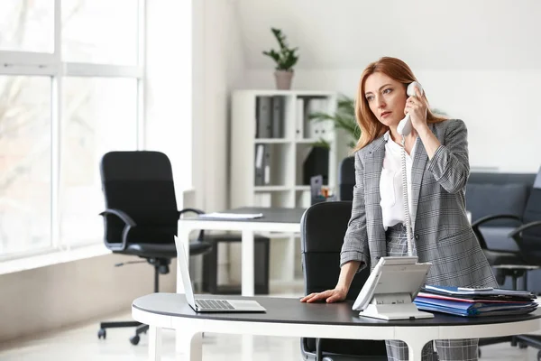 Retrato de empresária madura falando por telefone no escritório — Fotografia de Stock