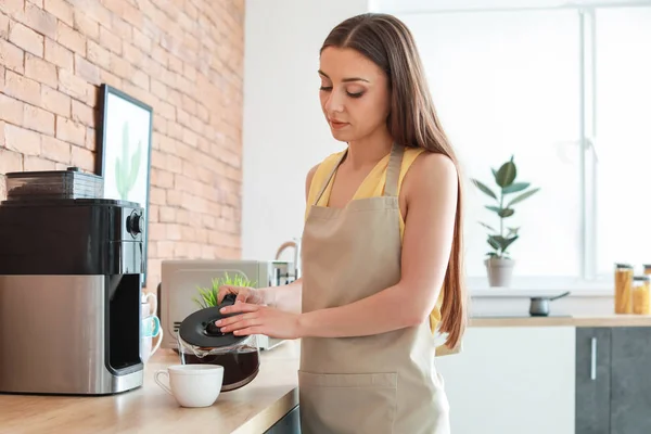 Mulher bonita usando máquina de café na cozinha — Fotografia de Stock