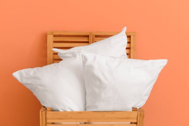 Renkli duvara karşı ahşap kutu yumuşak yastıklar