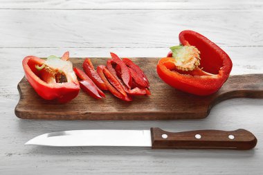 Ahşap arka plan üzerinde kesilmiş kırmızı biber ile Kurulu