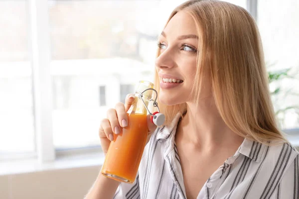 Mulher bonita bebendo suco fresco em casa — Fotografia de Stock