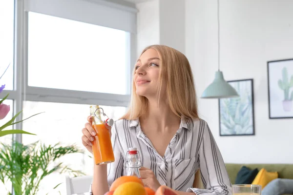 Mulher bonita bebendo suco fresco em casa — Fotografia de Stock