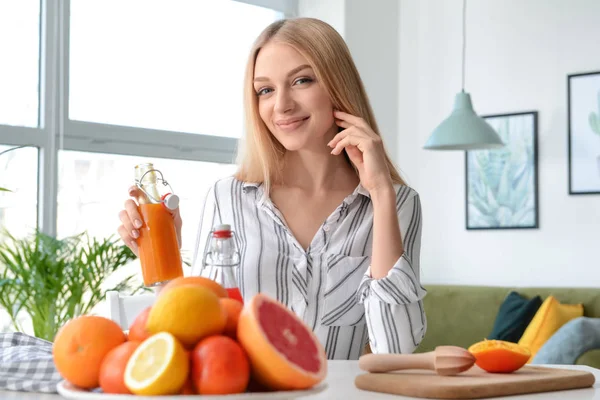 Hermosa joven bebiendo jugo fresco en casa — Foto de Stock