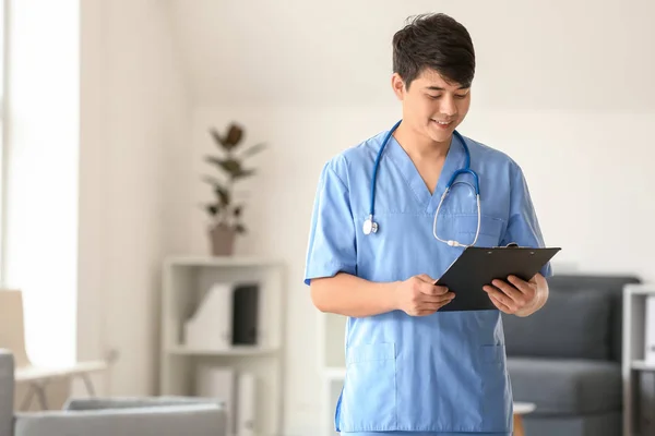 Male medical assistant with clipboard in clinic — Stock Photo, Image