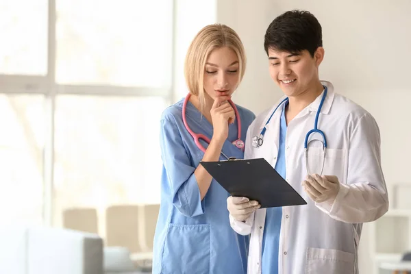 Doctor helping medical assistant with diagnosis in clinic — Stock Photo, Image