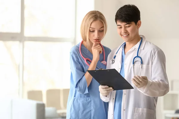 Médico ajudando assistente médico com diagnóstico na clínica — Fotografia de Stock