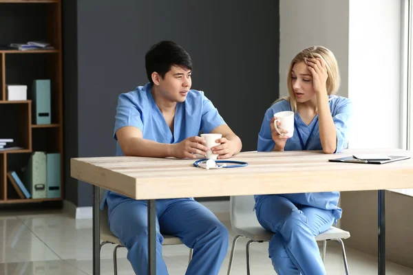 Jovens assistentes médicos que têm pausa durante o trabalho na clínica — Fotografia de Stock
