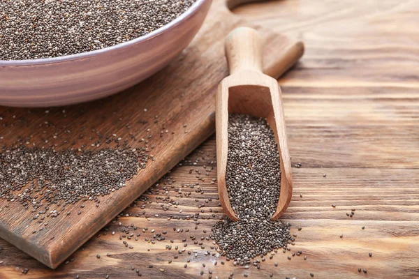 Scoop and bowl with chia seeds on wooden table — Stock Photo, Image