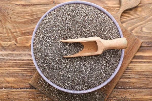 Scoop and bowl with chia seeds on wooden table — Stock Photo, Image