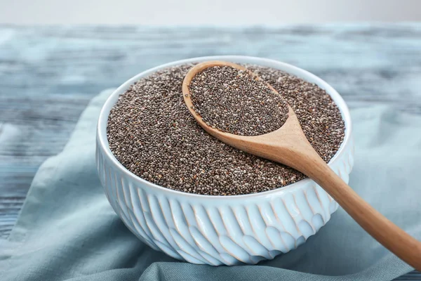 Spoon and bowl with chia seeds on table — Stock Photo, Image