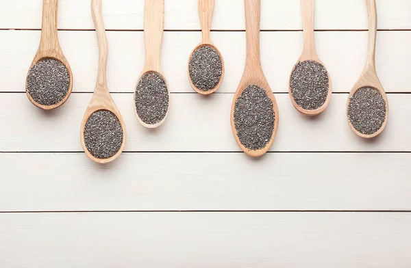 Spoons with chia seeds on wooden table — Stock Photo, Image