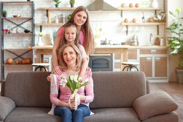 Gelukkig meisje met haar moeder en grootmoeder thuis — Stockfoto