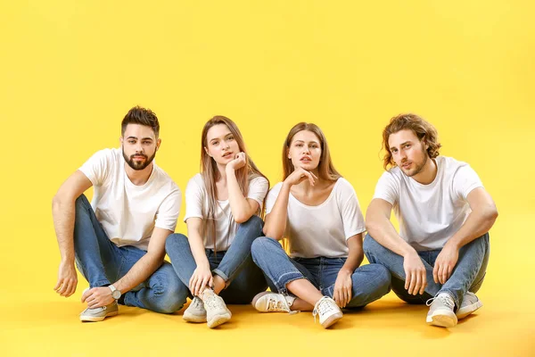 Стильные молодые люди в джинсах на цветном фоне — стоковое фото