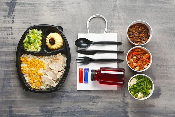 Behållare med utsökt mat och bestick på grå bakgrund — Stockfoto