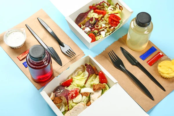 Containers met heerlijk eten en drinken op kleur achtergrond — Stockfoto