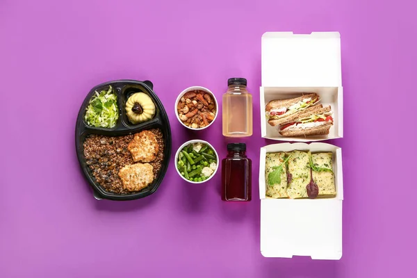 Containers met heerlijk eten en flesjes SAP op kleur achtergrond — Stockfoto