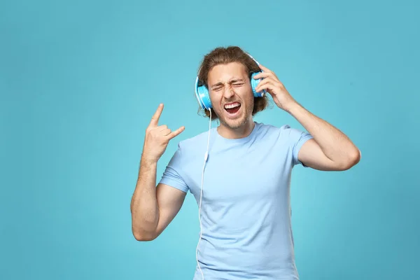 Bonito homem ouvindo música no fundo da cor — Fotografia de Stock