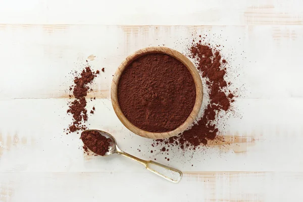 Cuenco con cacao en polvo sobre fondo de madera blanca —  Fotos de Stock