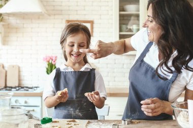 Evde mutfakta kurabiye hazırlama kızı ile mutlu anne