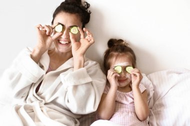 Mutlu anne ve sevimli kızı evde cilt bakımı tedavisi sırasında eğlenmek