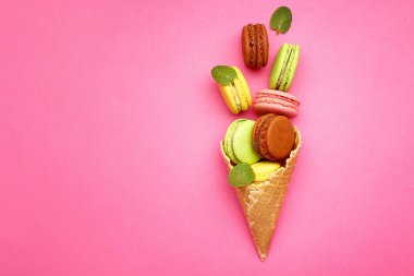 Renkli arka planda lezzetli makarnalar ile gofret konisi