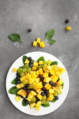 Gri arka planda lezzetli mango salatası ile tabak