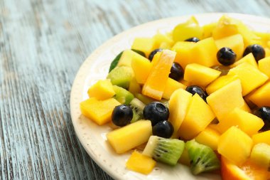 Ahşap masada lezzetli mango salatası ile Tabak