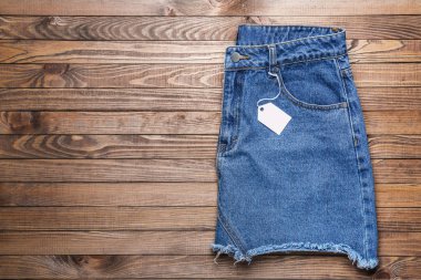 Ahşap arka plan üzerinde etiketi ile şık kot etek