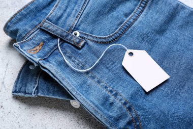 Hafif arka planda alışveriş etiketi ile Jeans pantolon