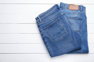 Beyaz ahşap masa üzerinde şık kot pantolon