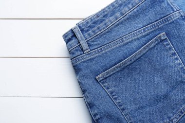 Beyaz ahşap masa üzerinde şık kot pantolon