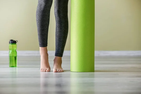 Молодая спортсменка с ковриком для йоги в спортзале — стоковое фото