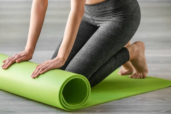 Spor salonunda yoga mat olan sportif kadın