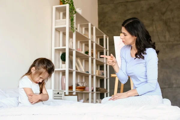 Mother scolding her naughty little daughter at home — Stock Photo, Image