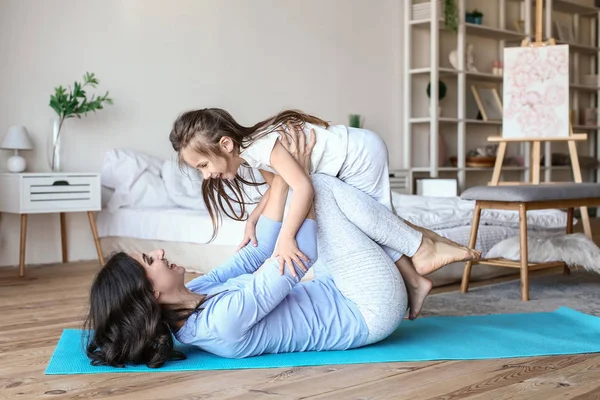 Moeder met kleine dochter doet oefeningen thuis — Stockfoto