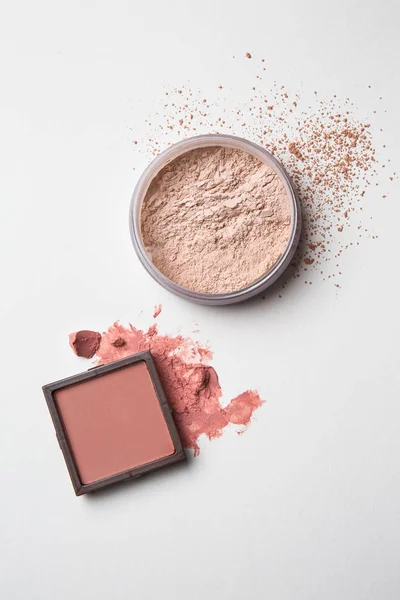 Blusher and facial powder on light background