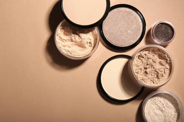 Different facial powder on color background