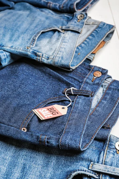 Calça jeans elegante com etiqueta na mesa, close-up — Fotografia de Stock