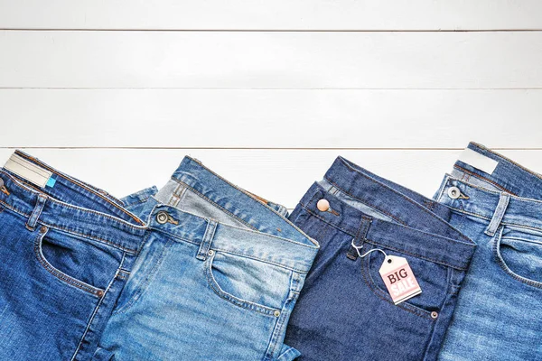 Elegantes jeans con etiqueta sobre fondo de madera —  Fotos de Stock