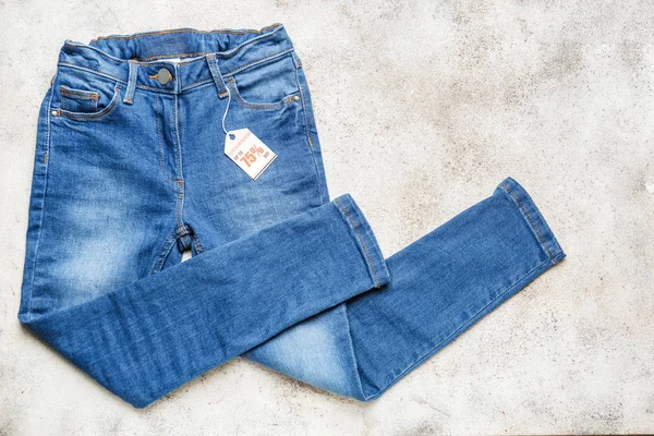 Calça jeans elegante com etiqueta no fundo claro — Fotografia de Stock