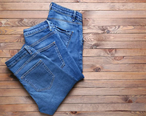 Calça jeans elegante no fundo de madeira — Fotografia de Stock