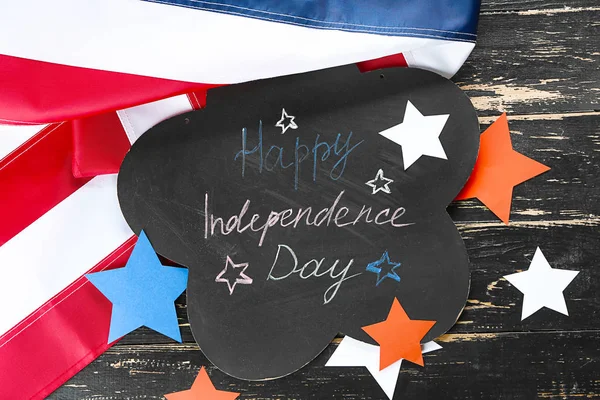 Card with text HAPPY INDEPENDENCE DAY, USA flag and stars on wooden background — Stock Photo, Image