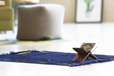 Müslüman dua mat Üzerinde Kur'an-ı Kerim standı