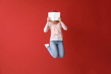 Renkli arka plan kitap ile atlama genç kadın