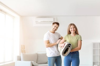 Yeni dairede halısı olan genç çift.